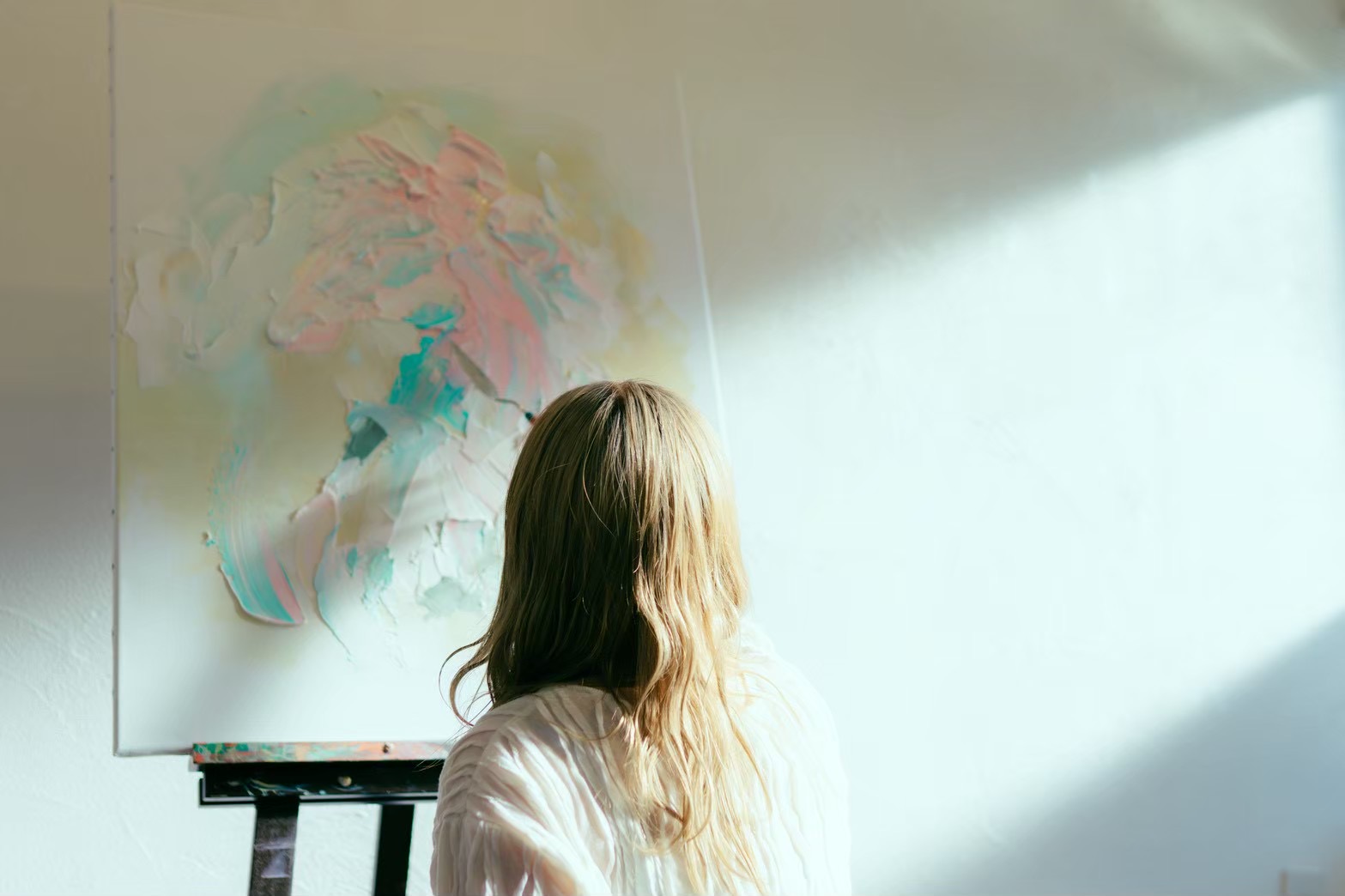 光の差す部屋で作品に向き合う後ろ姿